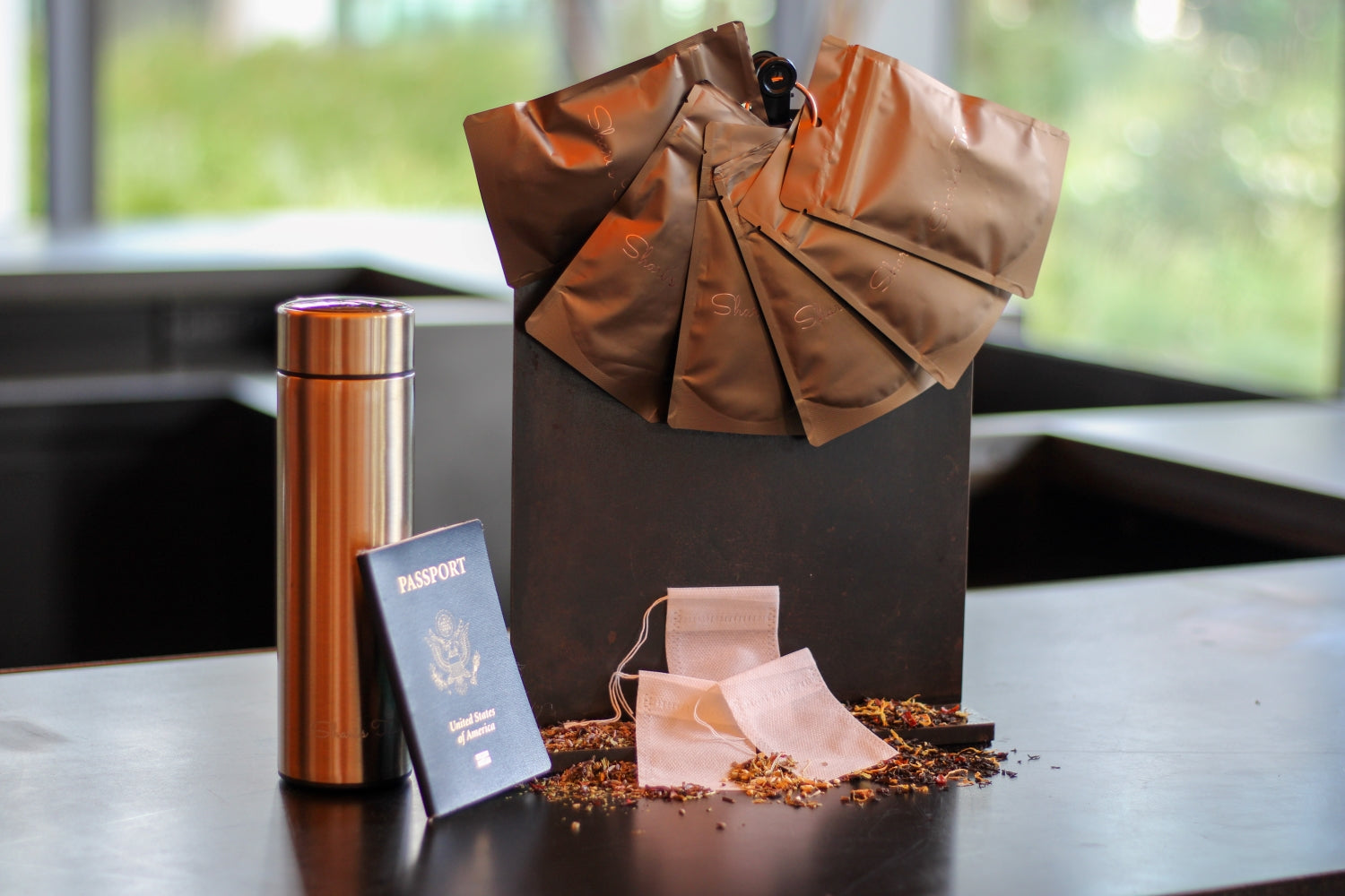 Close-up of Shari's to go kit with tea travel thermos and passport